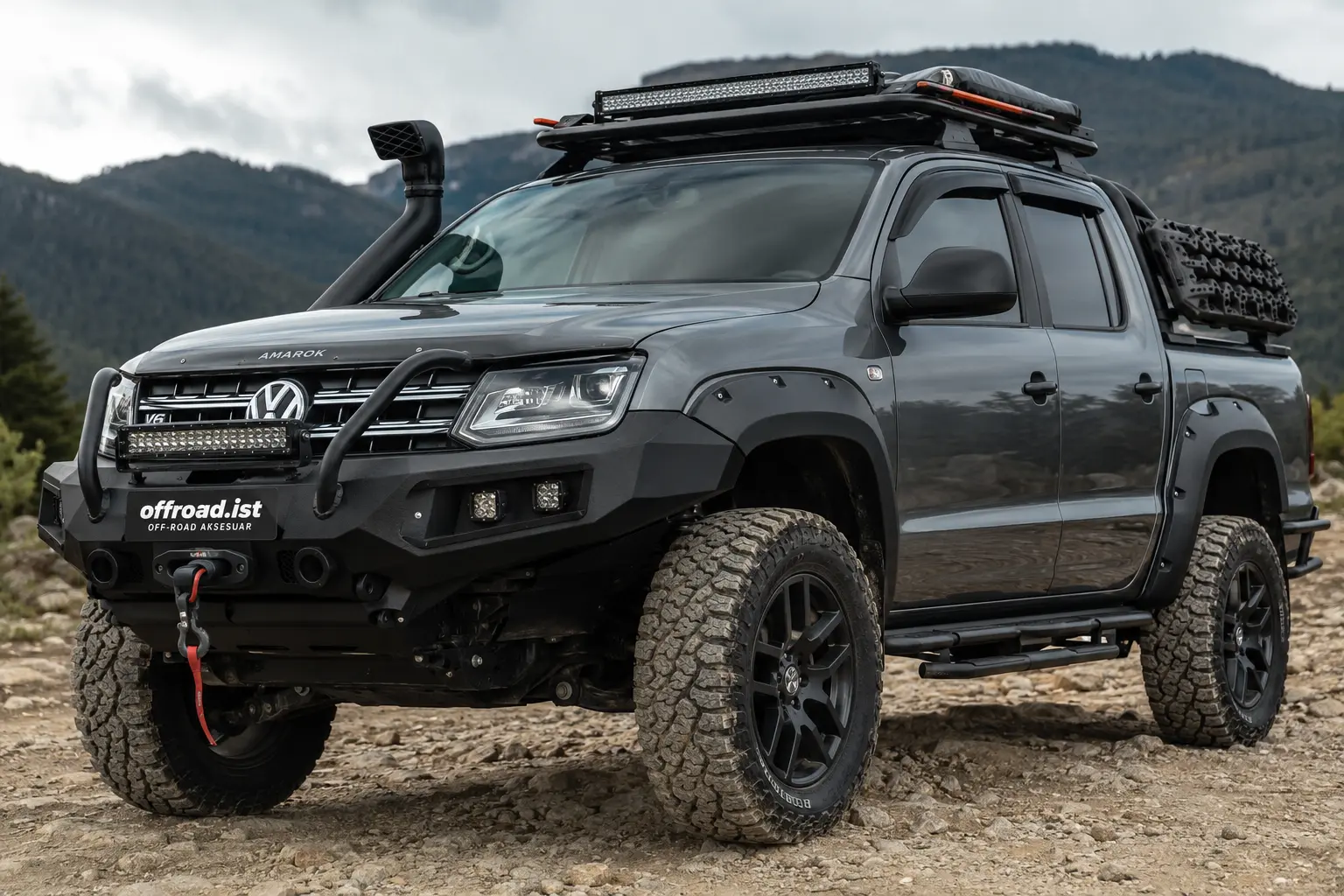 Volkswagen Amarok üzerine monte edilmiş off-road ön tampon, vinç, şnorkel, LED bar, tavan platformu ve arazi lastikleriyle donatılmış modifiye pickup aracı.